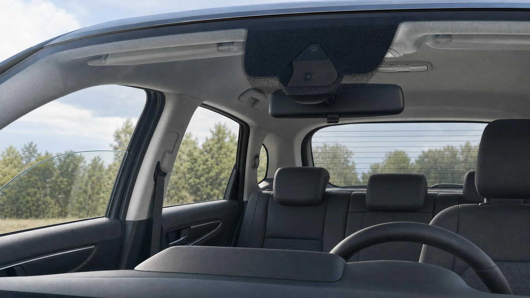 Illustration: Der Innenraum eines Autos mit Rückspiegel, Frontscheibe, Sitzen und Lenkrad ist zu sehen; durch die Fenster sind Bäume und Himmel sichtbar.